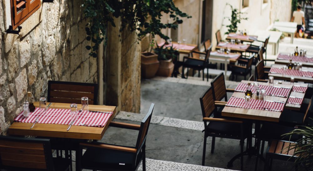 A restaurant in a side passage with tables and chairs outdoors, which is common to see when eating out in Albufeira old town