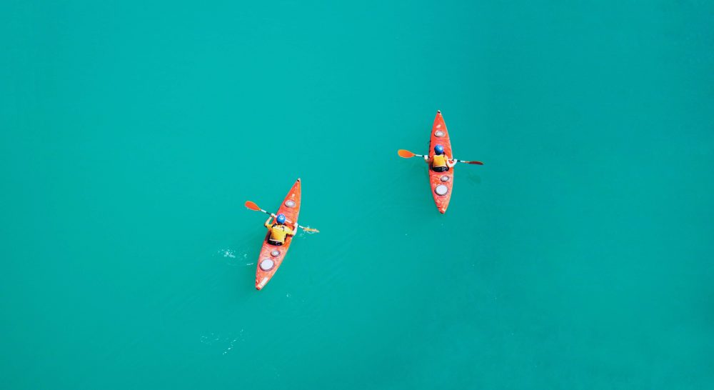 two people kayaking in the middle of the ocean in the algarve