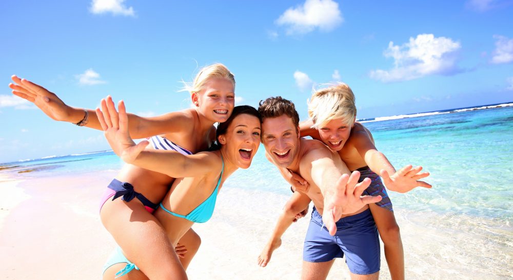 family smiling on a beach